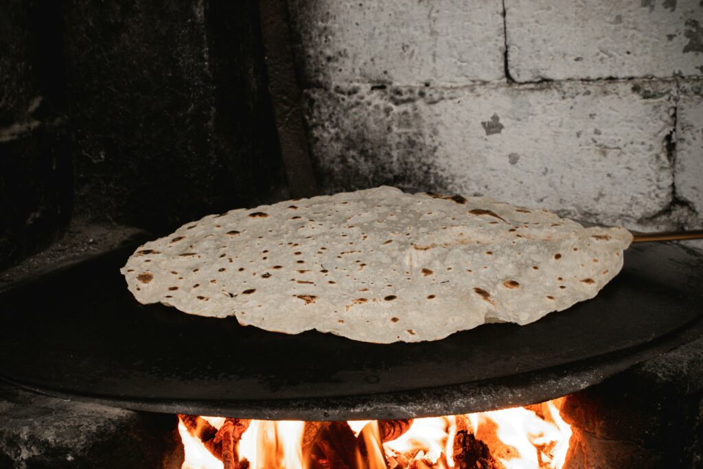Delicious traditional flatbread baking over an open flame in Malatya, Türkiye, showcasing local culinary heritage.